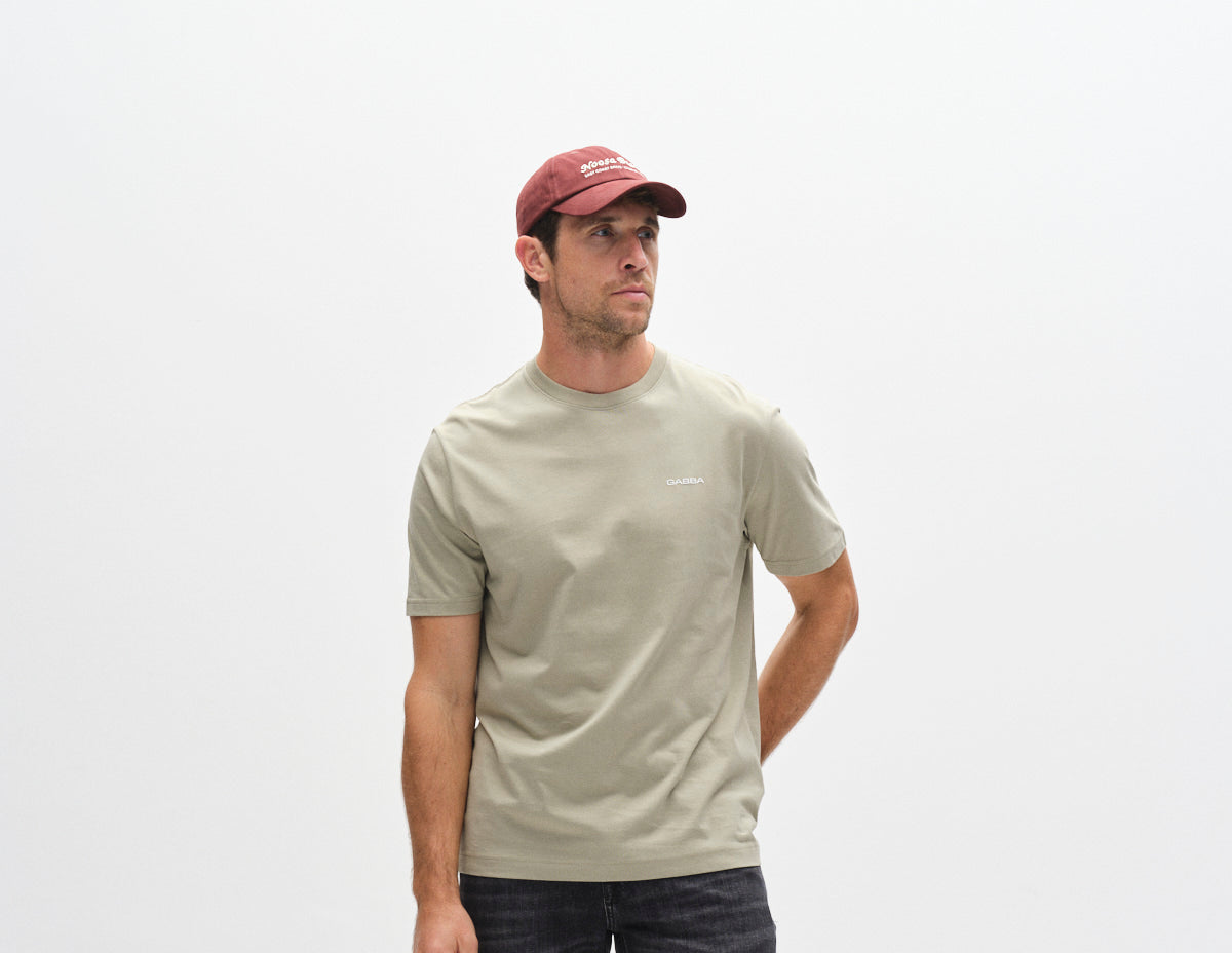 Lichtgroen T-shirt met logo op de borst, model in zijaanzicht