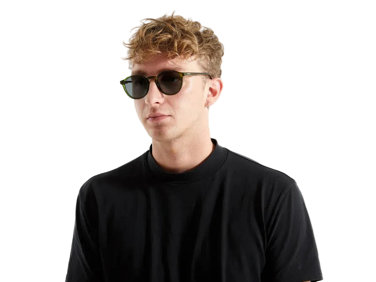 Zonnebril op gezicht van man met donkerbruin montuur en donkere glazen LAB10MENSWEAR.NL