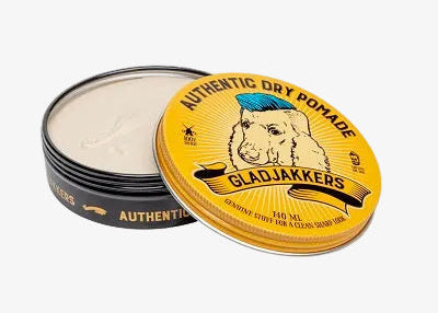 Open pomadeblik met gele deksel en witte inhoud.