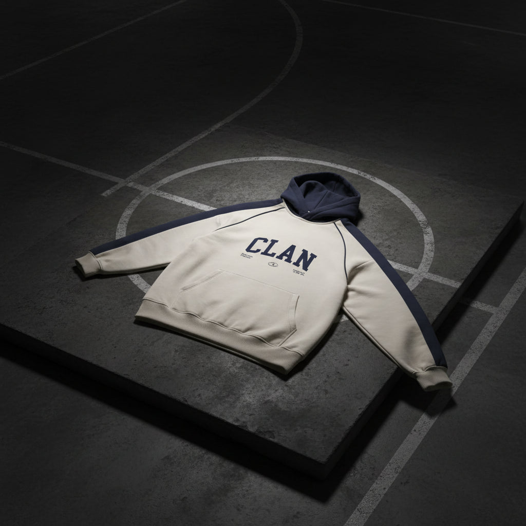 Crème hoodie met marineblauwe capuchon en mouwen, CLAN-logo op de borst.